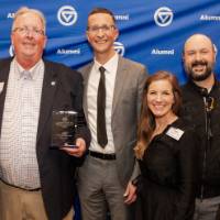 Bob Stoll smiles with his award and his family